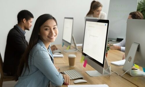 Smiling,Asian,Office,Employee,Looking,At,Camera,Working,With,Multiracial