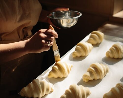 Female,Baker,Smears,Raw,Croissants,With,A,Brush,In,The Female,Baker,Smears,Raw,Croissants,With,A,Brush,In,The